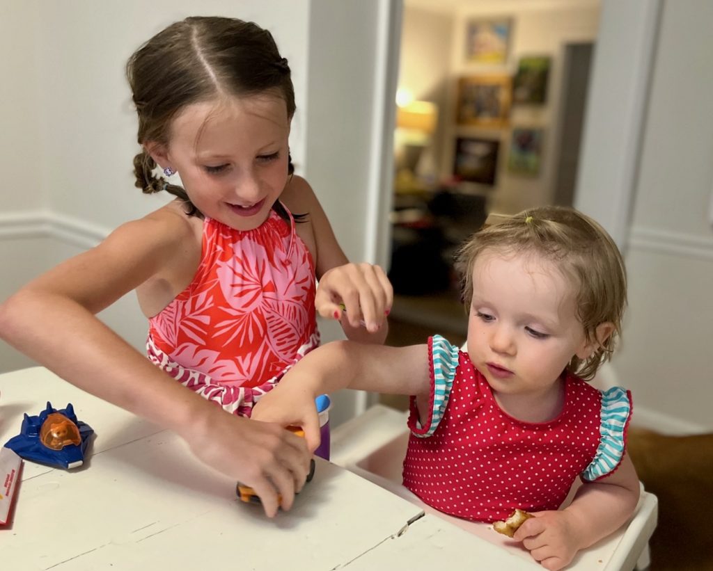 Rosie helping mercy with her happy meal toy